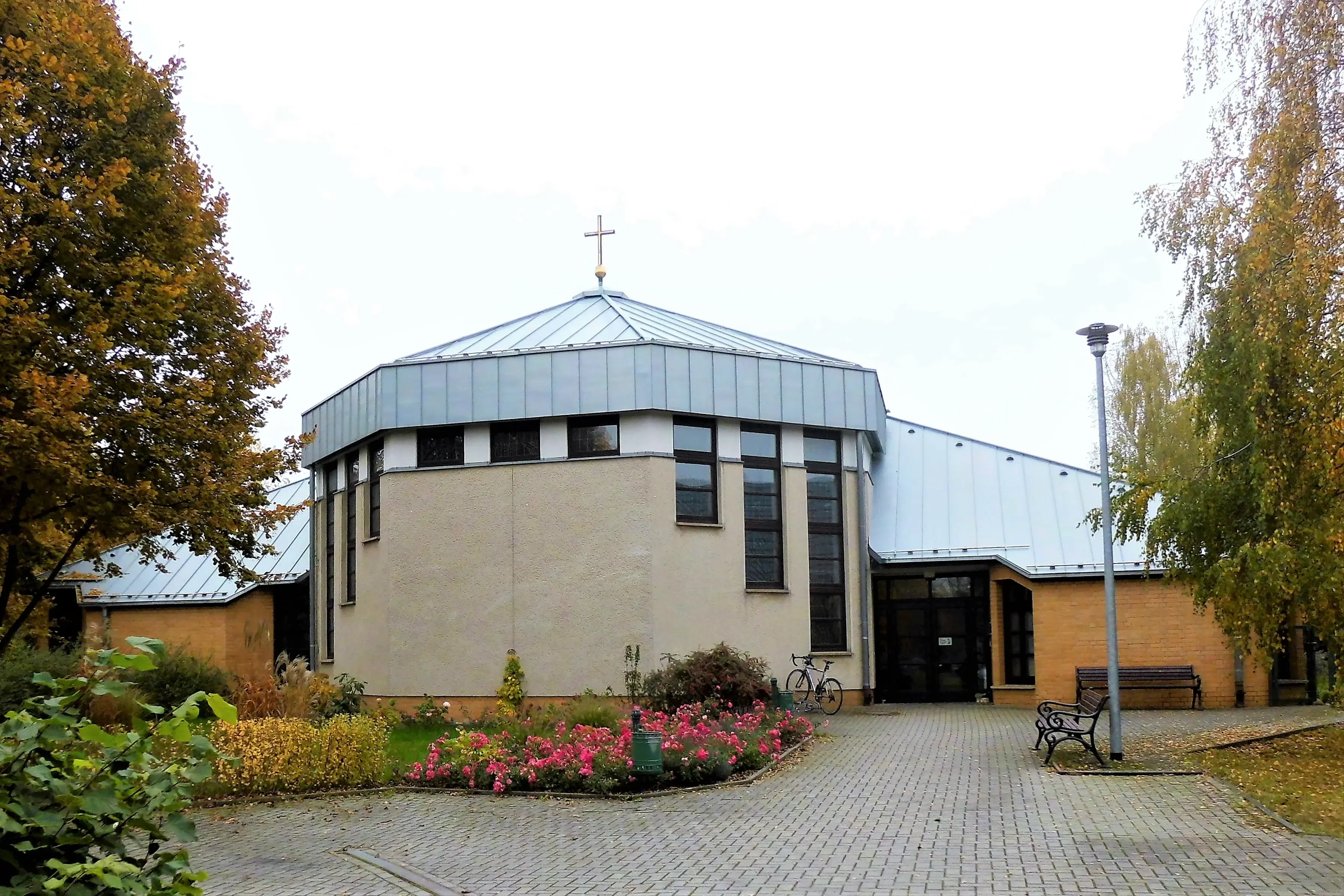 Vordereingang der kirche mit Rosenbeet